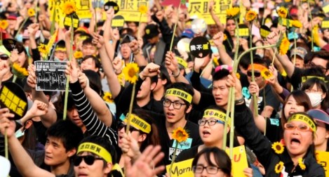 Demonstrators holding sunflowers shout slogans in front of the Presidential Office in Taipei